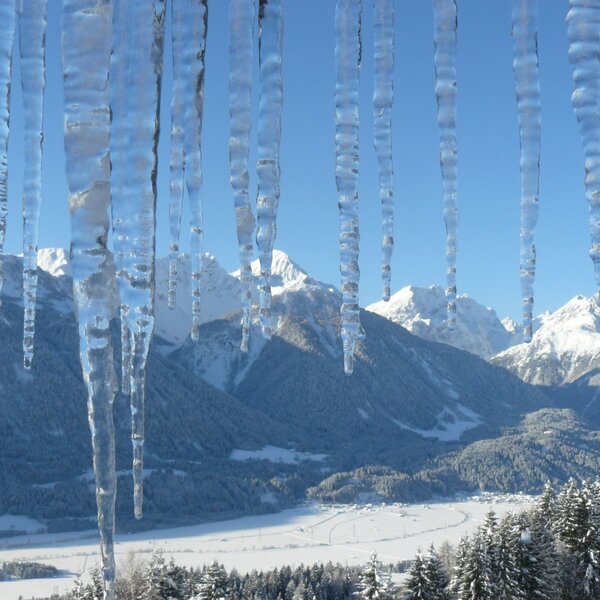The winter mountain and valley view from the Farm House, featuring icicles in the foreground. The winter mountain and valley view from the Farm House, featuring icicles in the foreground.