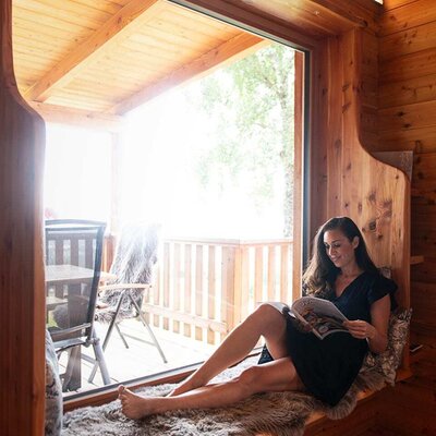 Seating area by the panoramic window in the Chalet with a fur throw and a view of the terrace.