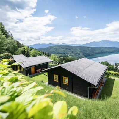Several holiday homes on a hillside with a view of the lake and surrounding mountains.