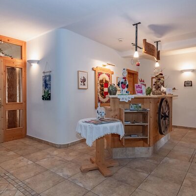 The farm house reception desk with wooden details, display shelves, and traditional ski equipment mounted on the wall.