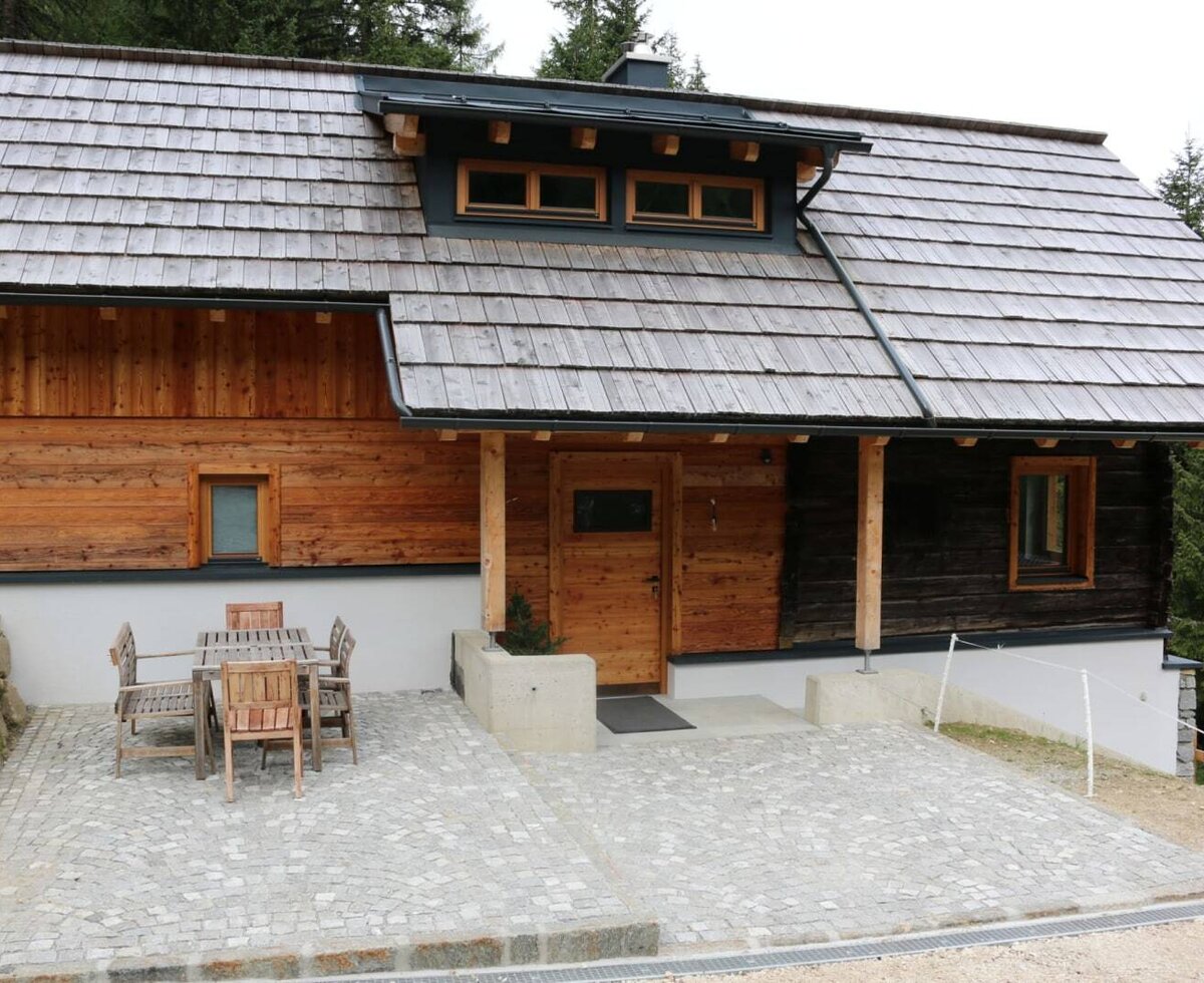The rustic Alm's inviting paved terrace, complete with cozy wooden seating.