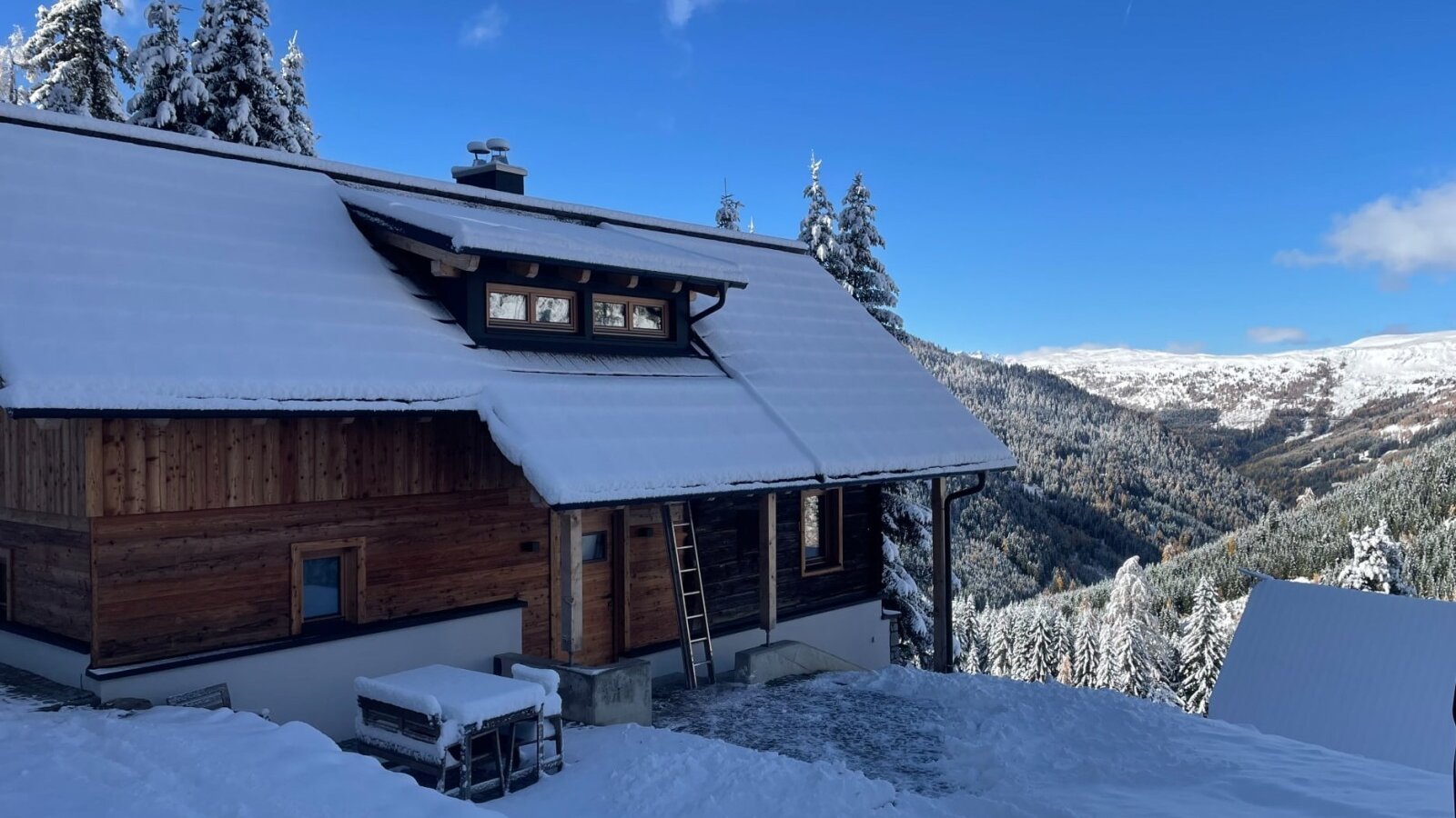 The traditional Alm, nestled in a snow-covered winter landscape with scenic mountain views.