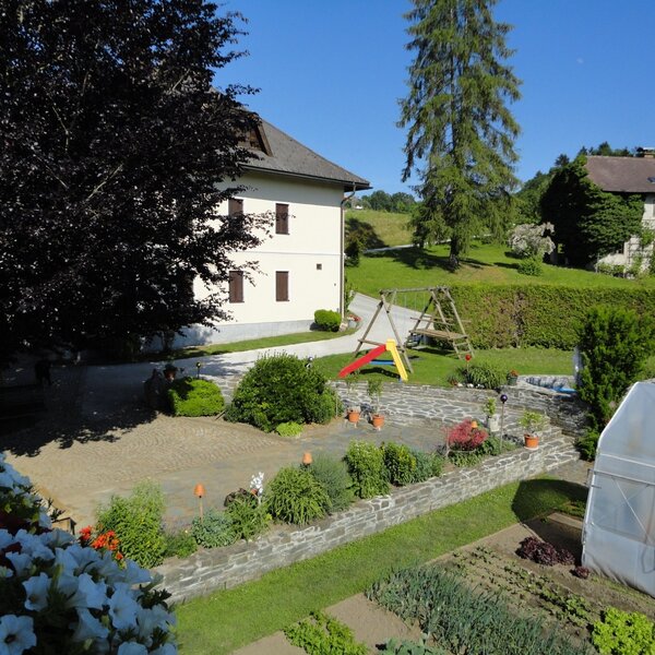 The farm house grounds feature a garden area with a children's playground and a vegetable patch with a greenhouse.