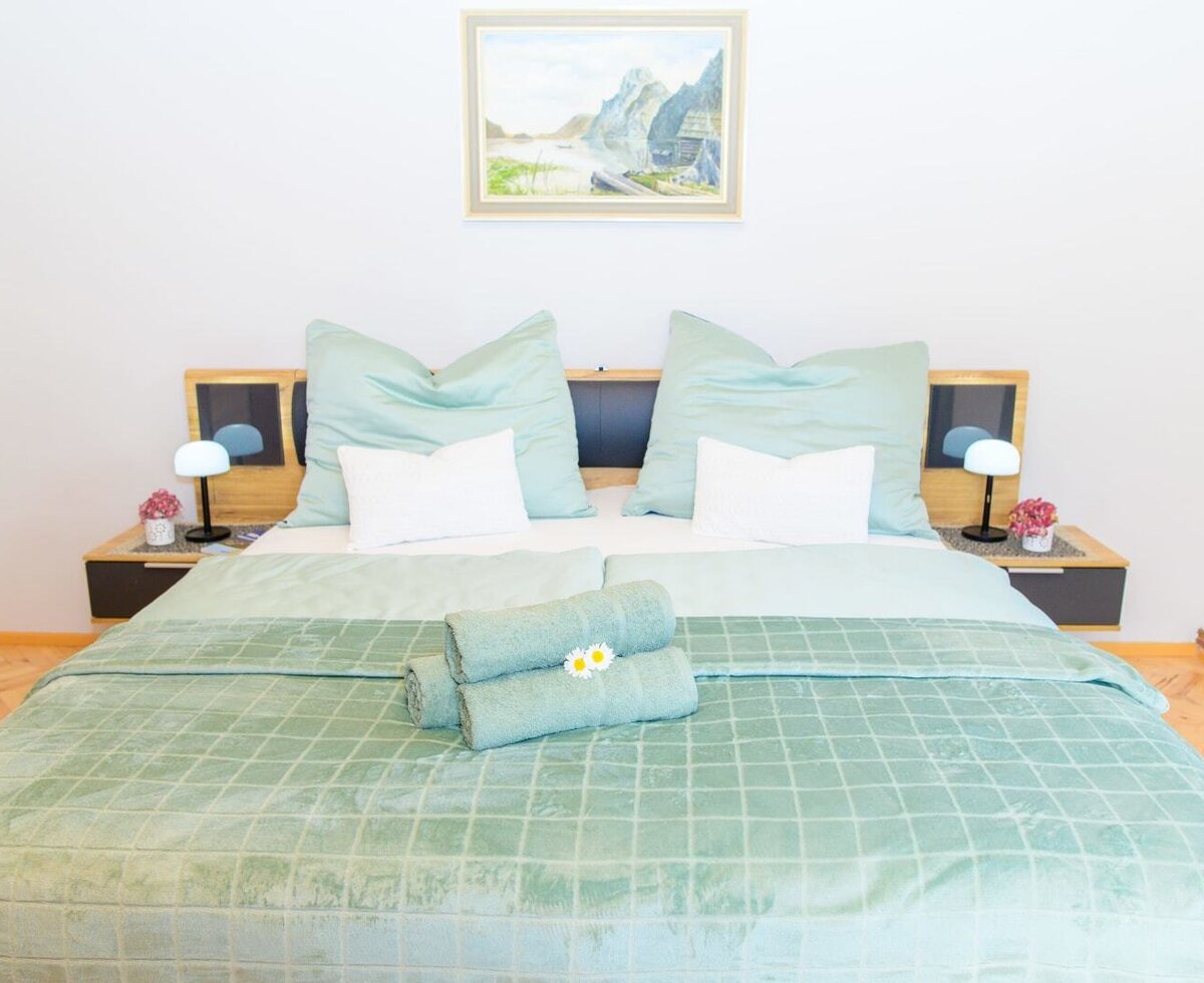 Double bedroom in the farmhouse featuring a double bed, two bedside tables with lamps, and a wooden wardrobe.