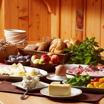 Breakfast served at the Farm House with an assortment of bread, fresh fruit, cheeses, cold cuts, and cereals.