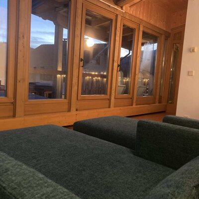Seating area in the farmhouse with large wooden windows providing an outdoor view.