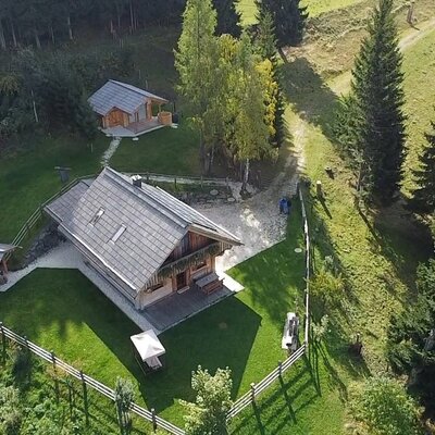 Aerial view of the Alpine Hut, including a separate cabin with an outdoor hot tub and a private fenced lawn.