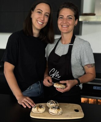Two people in the Bauernhof kitchen with freshly baked rolls.
