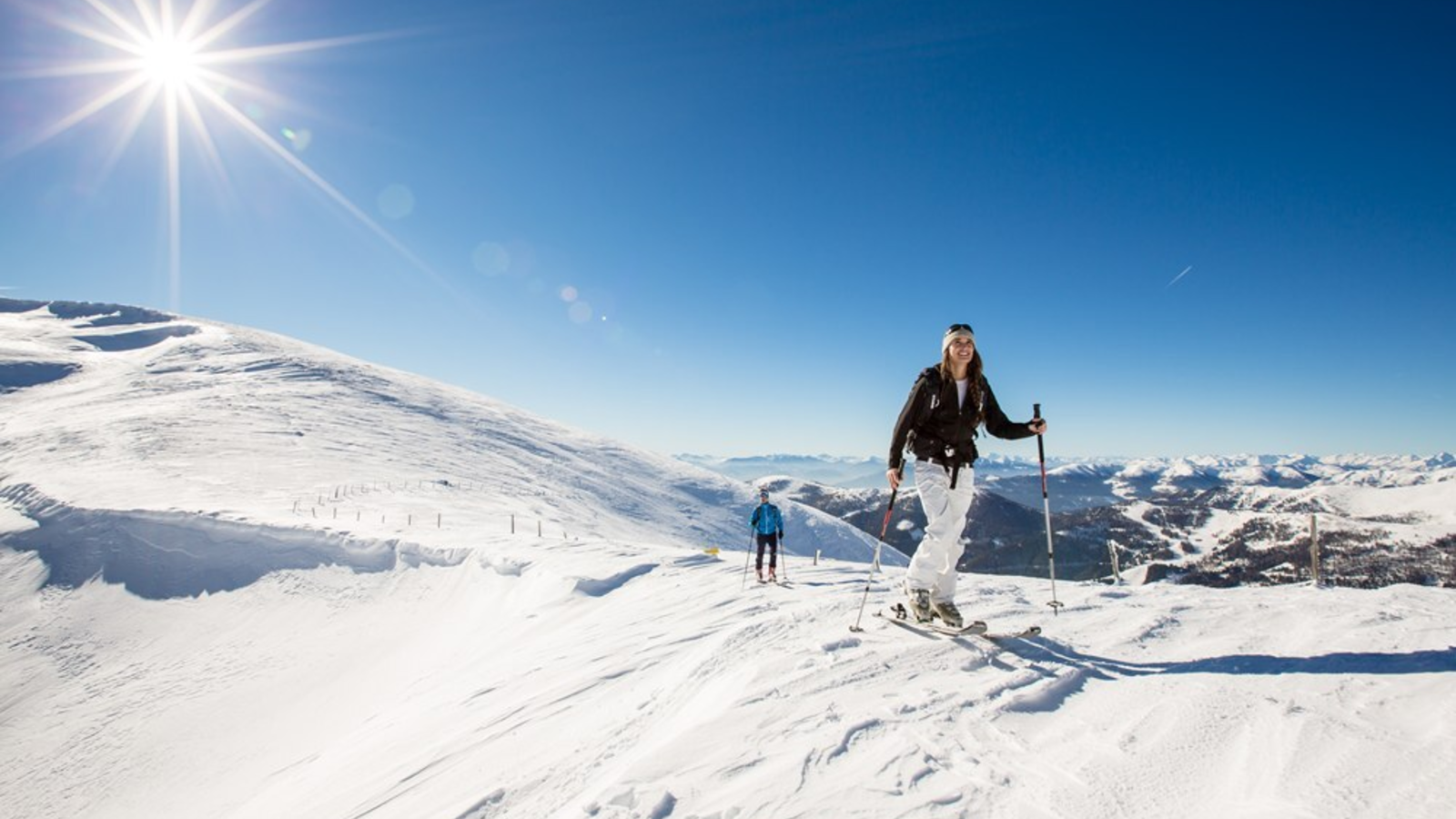 Ski touring on a snowy mountain under a blue sky, an activity available near the farmhouse.