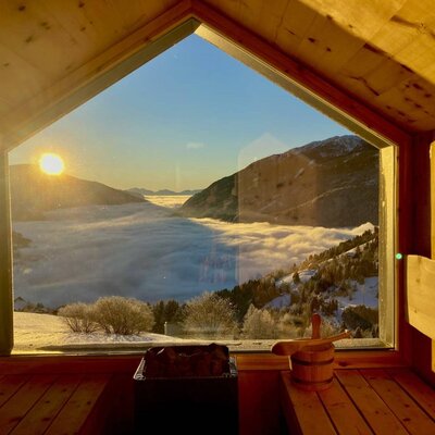 Panorama sauna @Strobl Alm with sunrise above the sea of fog in the valley