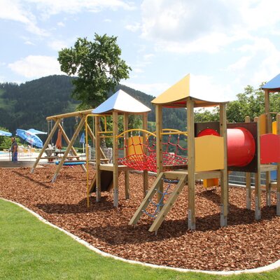 Playground with a swing, slide, climbing frame, and tunnel for the apartments.