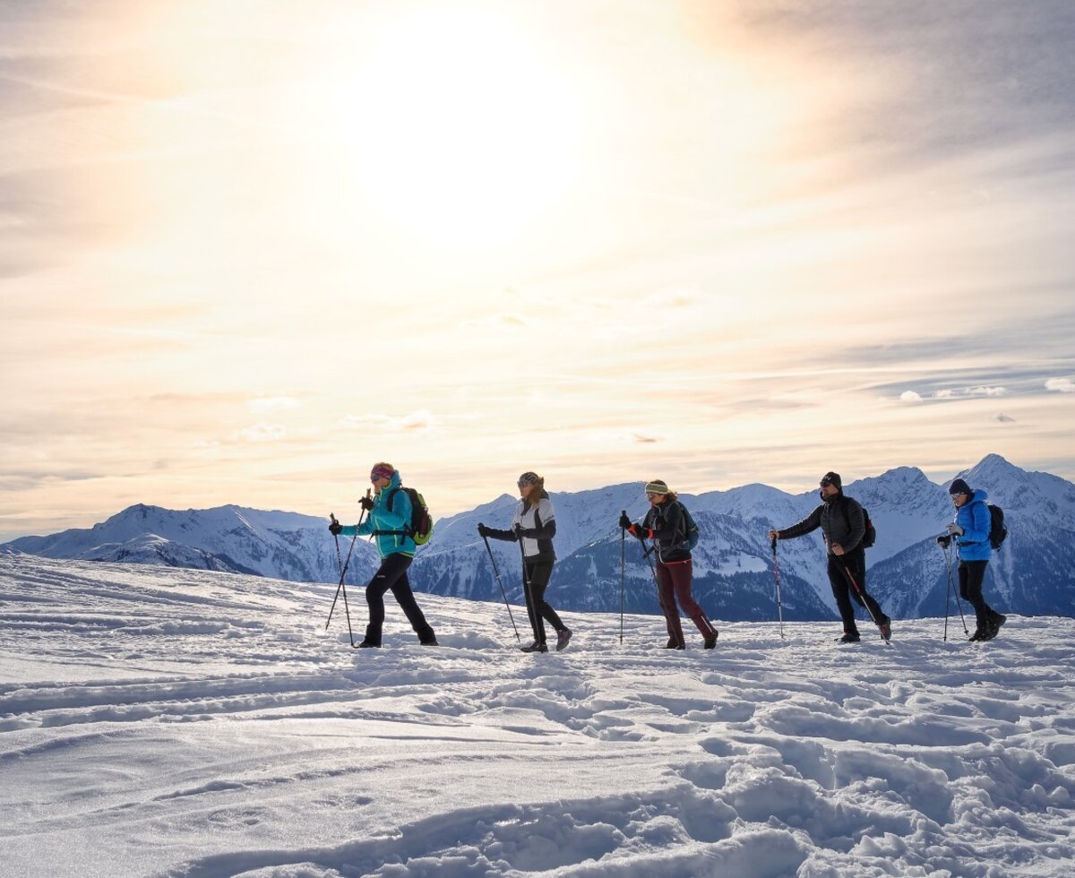 A group on a winter hike across a snowy mountain landscape, representing outdoor activities available from the Farm House.