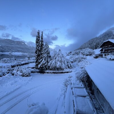 A snowy view from the farm house, featuring the lake and surrounding mountains.
