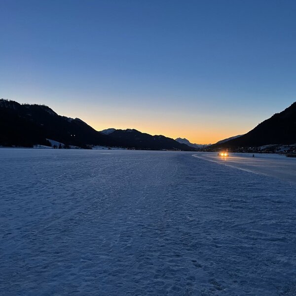 View of the frozen lake and surrounding mountains at sunset, characteristic of the Farm House's location. View of the frozen lake and surrounding mountains at sunset, characteristic of the Farm House's location.
