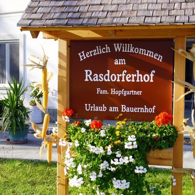 The main welcome sign for the Rasdorferhof Farm House features decorative flowers and dried corn.