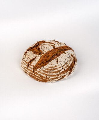 A round loaf of farm bread with a dark crust, ready for breakfast at the Bauernhof.