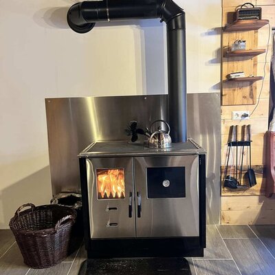 An inviting wood-burning stove with a crackling fire, bringing cozy warmth to the rustic Alm.