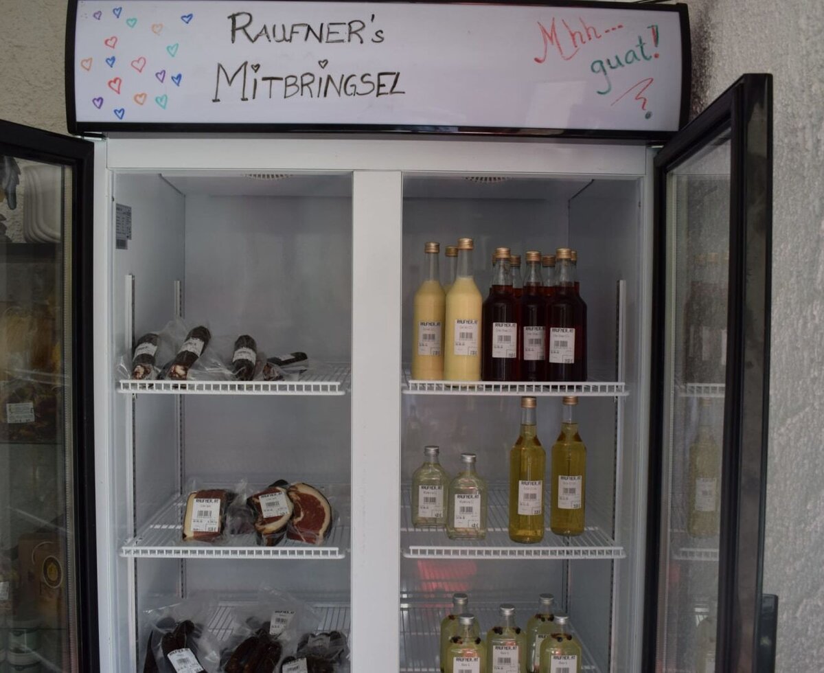 A well-stocked display fridge at Gasthof Raufner offering regional specialties and homemade souvenirs.