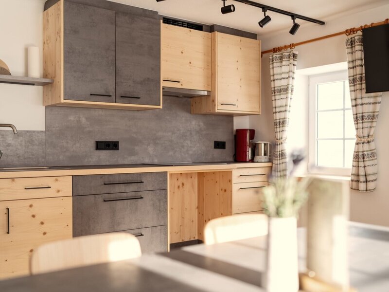 The modern kitchen in the farmhouse is equipped with wooden and grey cabinets, a sink, stovetop, coffee machine, and a window.