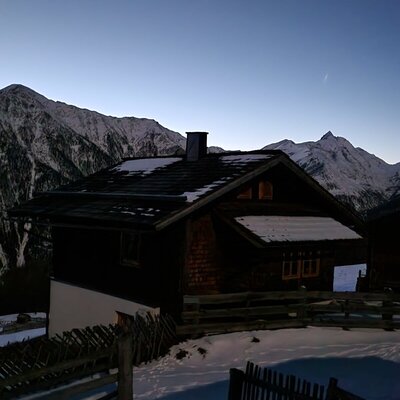 The Alm in the snow with a view of the surrounding mountains.