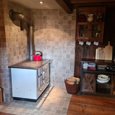 The cozy kitchen of the cabin, featuring a traditional wood-burning stove and rustic wooden cabinets.