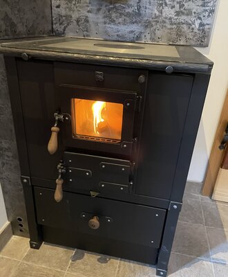 The chalet's wood-burning fireplace with an active fire.