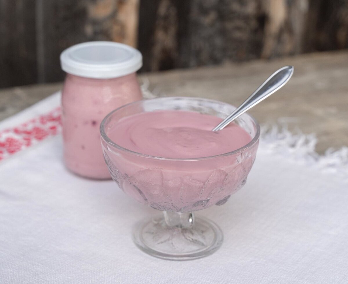 Yogurt in a glass bowl with a spoon and a jar, available for guests at the Alpine Hut.