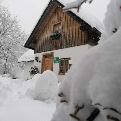 The Farm House exterior blanketed in snow during winter.