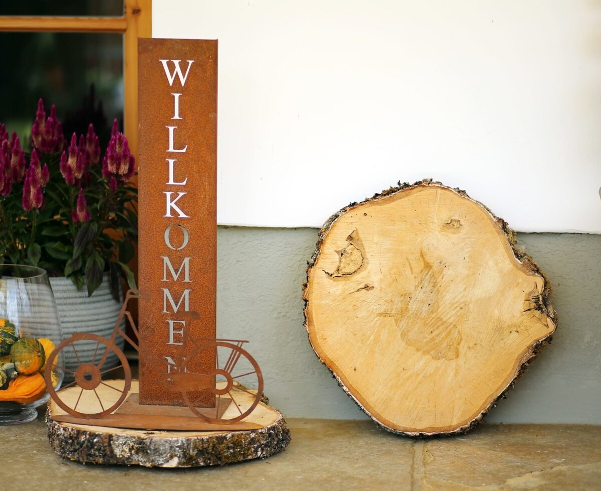 The entrance to the Farm House features a 'Willkommen' sign, a display of ornamental gourds, and potted flowers.