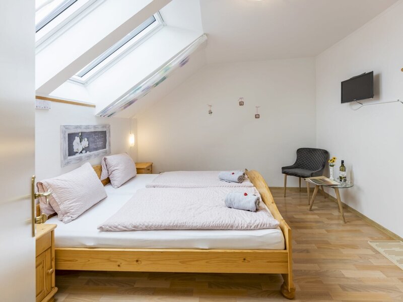 Bedroom in the Haus featuring two single beds, skylight windows, and a wall-mounted SAT TV.