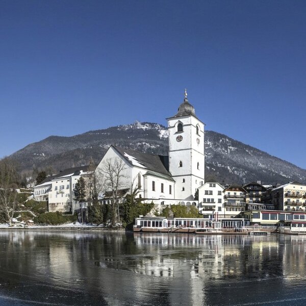 Lake Wolfgangsee with the village, its pilgrimage church, and snow-capped mountains, showcasing the scenic surroundings of the farmhouse. Lake Wolfgangsee with the village, its pilgrimage church, and snow-capped mountains, showcasing the scenic surroundings of the farmhouse.
