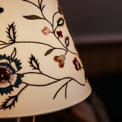 An embroidered lampshade with a floral pattern in the farm house.