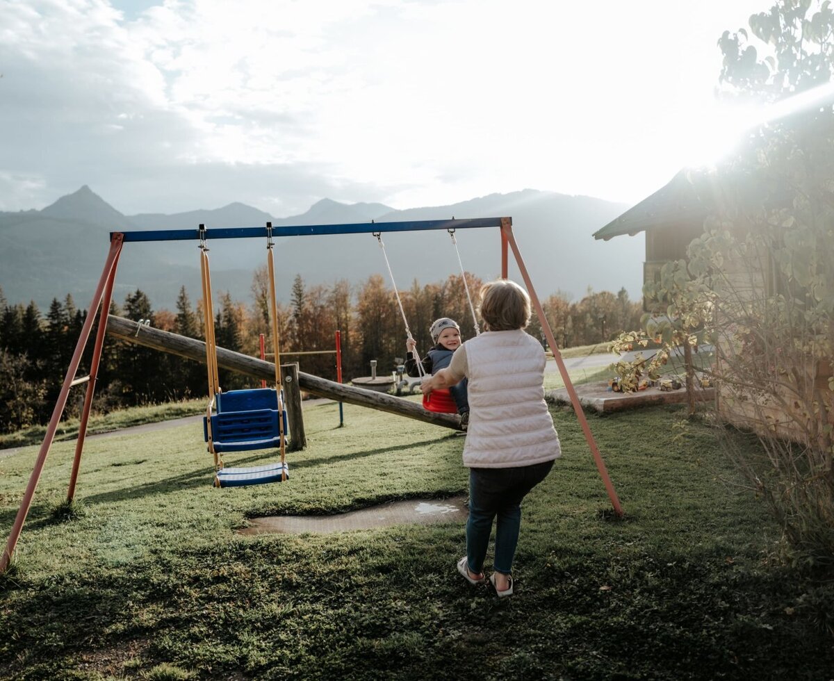 The outdoor playground at the farm house, equipped with swings and offering views of the surrounding mountains.