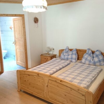 Double bedroom in the farm house with solid-wood furniture, including a bed and nightstands, and direct access to a private bathroom.