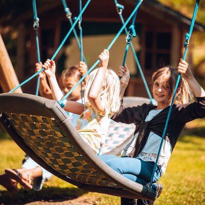 The garden at the Farm House, featuring a swing set for children.