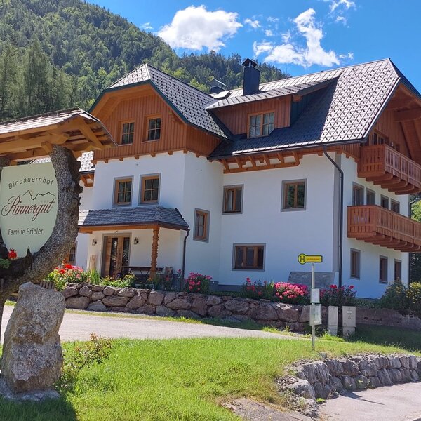 Exterior view of the Rinnergut Bauernhof, featuring wooden balconies and the 'Biobauernhof Rinnergut Familie Prieler' sign.