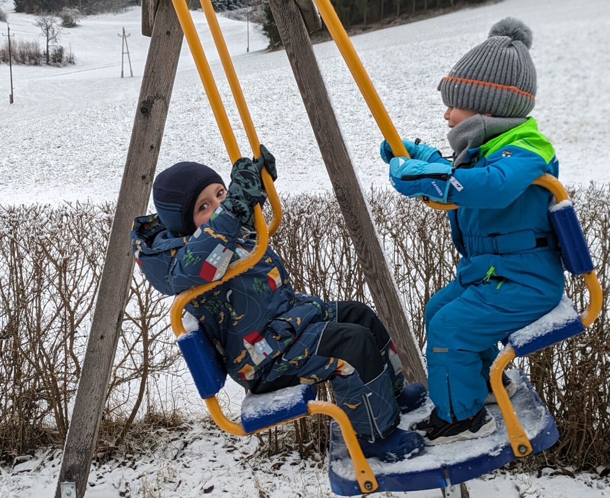 The Farm House provides a children's swing set in the snowy outdoor area.