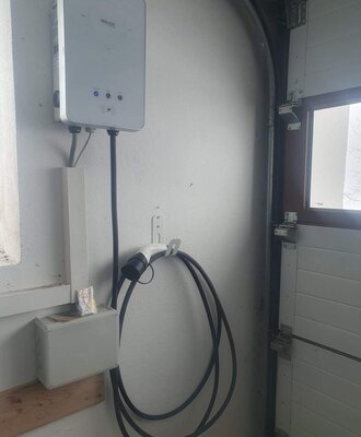 EV charging station with charging cable and plug at the farmhouse.