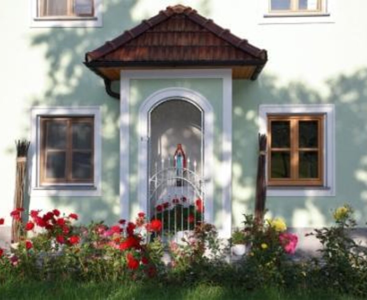 The farm house exterior features a built-in wall shrine with a statue, surrounded by a garden with roses.