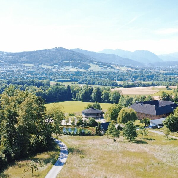 Scenic view of the organic farm with its cozy apartments, surrounded by lush meadows, forests, and rolling hills.