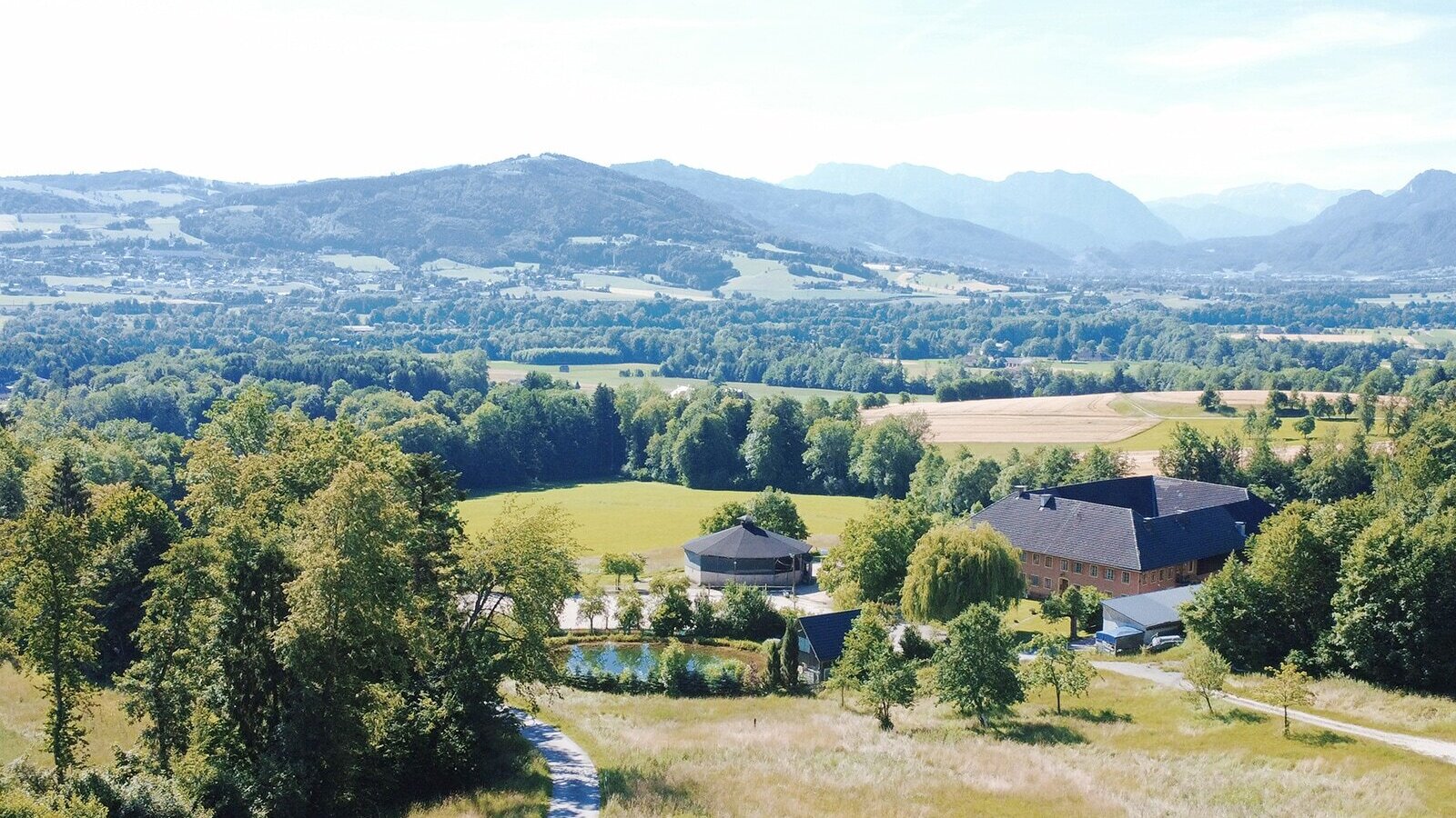 Scenic view of the organic farm with its cozy apartments, surrounded by lush meadows, forests, and rolling hills.