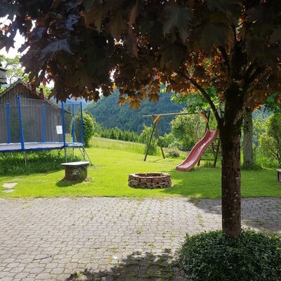 The farm house features an outside play area with a trampoline, a swing set with a slide, a fire pit, and a sandpit.