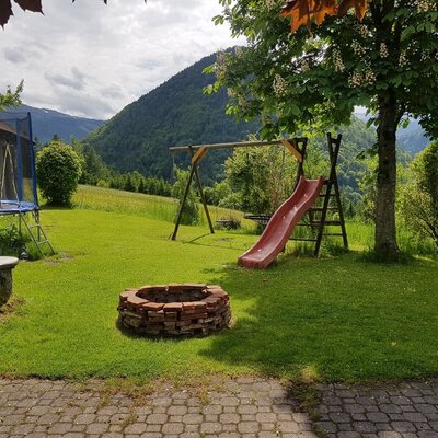 The farm house offers an outdoor play-area with a trampoline, swing, and slide, alongside a brick BBQ area for guests.