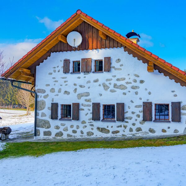 The exterior of the farm house features a white facade with visible stone accents, wooden shutters, and a terracotta-tiled roof, set amidst a partially snow-covered landscape. The exterior of the farm house features a white facade with visible stone accents, wooden shutters, and a terracotta-tiled roof, set amidst a partially snow-covered landscape.