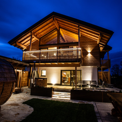 Barrel sauna and hot tub in the garden area of the chalet