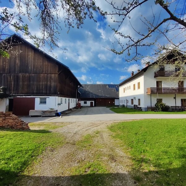 Exterior view of the farmhouse with a barn and residential building.