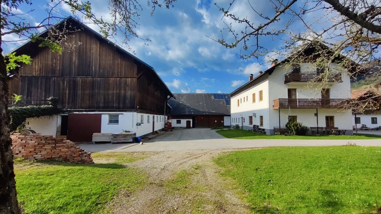 Exterior view of the farmhouse with a barn and residential building.