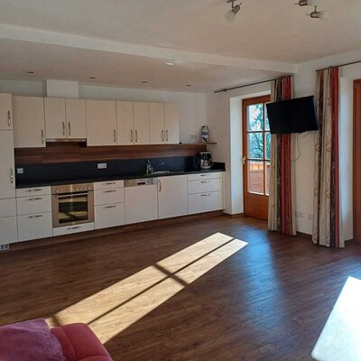 The farm house kitchen includes an oven, dishwasher, wall-mounted TV, and direct access to a balcony.