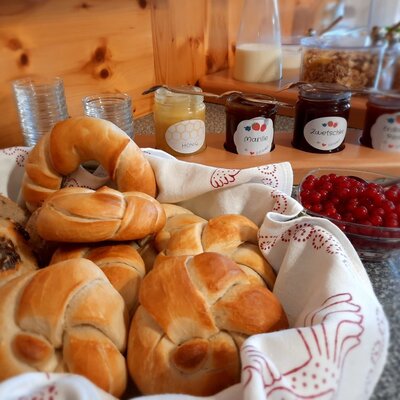 Breakfast offerings at the Farm House include a basket of bread, various jams, honey, granola, milk, and red currants.