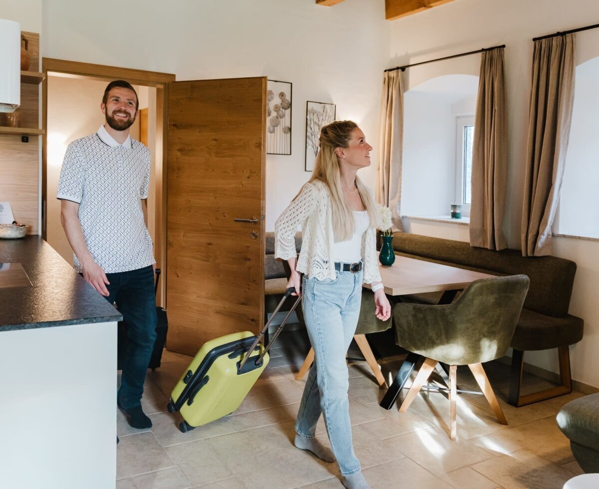 Guests arriving at the apartment, featuring an open-plan kitchen and dining area.